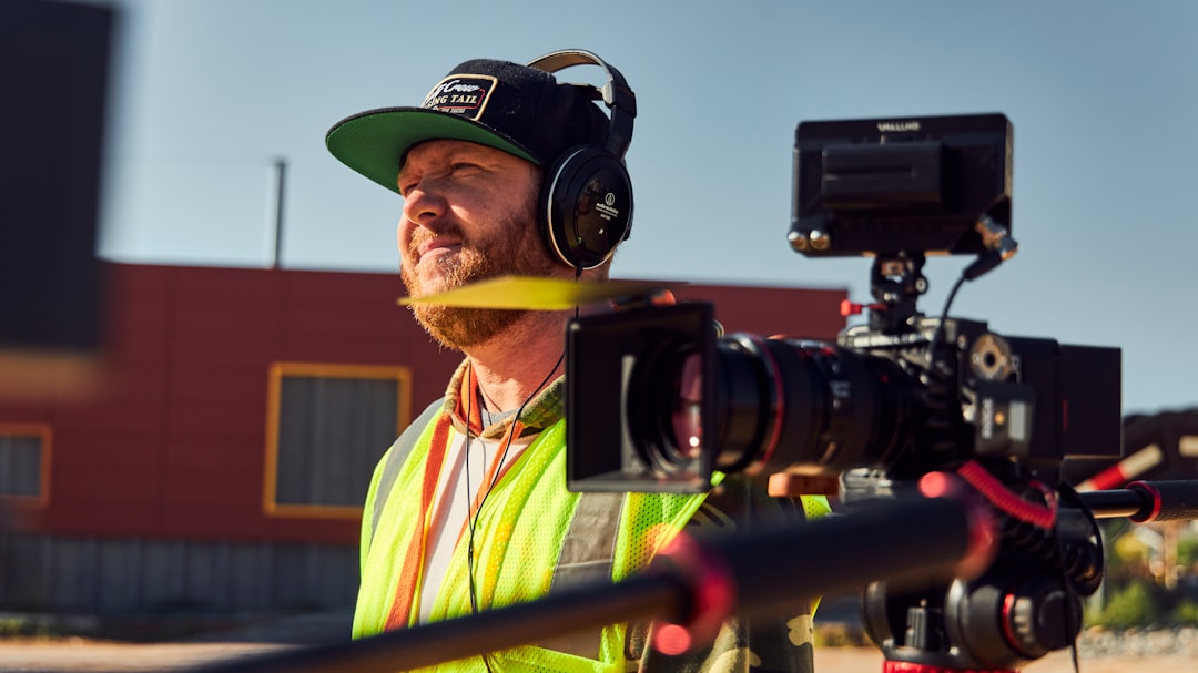 a man in a yellow vest and a green hat